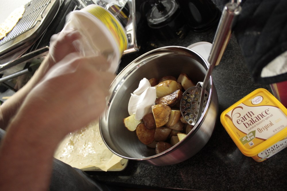 vegan cream cheese being added to roasted potatoes